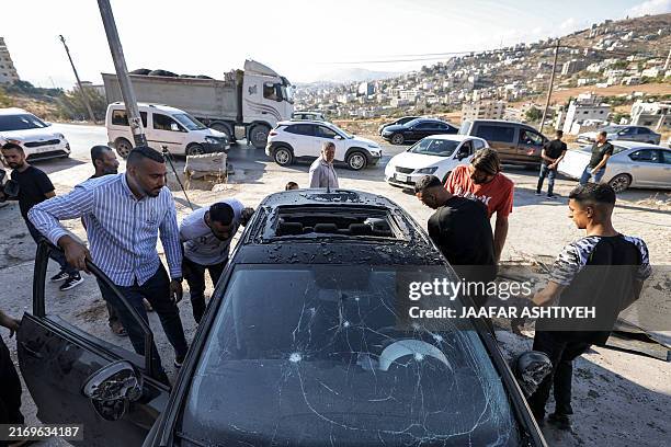 Men inspect a vehicle that was targeted by an Israeli air strike in Tubas in the north of the occupied West Bank on September 5, 2024 amid a...