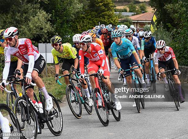 Team Decathlon-AG2R La Mondiale's Ben O'Connor, wearing the overall leader red jersey, rides with the pack during the stage 18 of the Vuelta a...