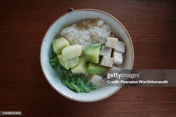 a close-up view of a refreshing traditional thai dessert featuring a mix of diced taro, green pandan noodles - taro stock pictures, royalty-free photos & images