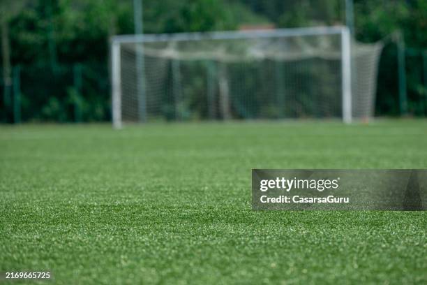 kunstrasen auf dem fußballplatz - fußballplatz stock-fotos und bilder