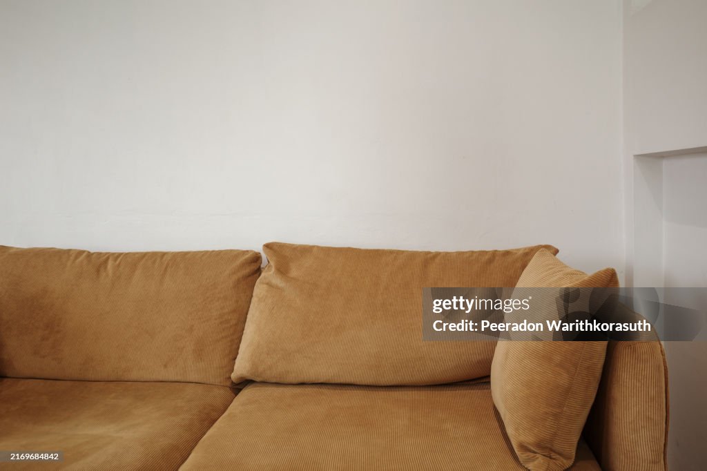Comfortable brown corduroy sofa positioned against a white wall.