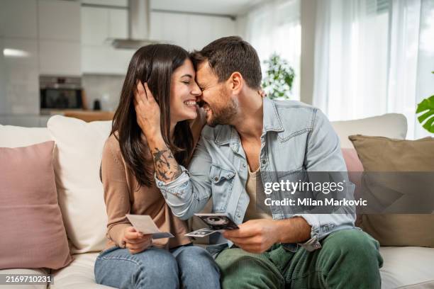 dreams come true, a young couple is excited while watching the ultrasound of their future child - two parents stock pictures, royalty-free photos & images