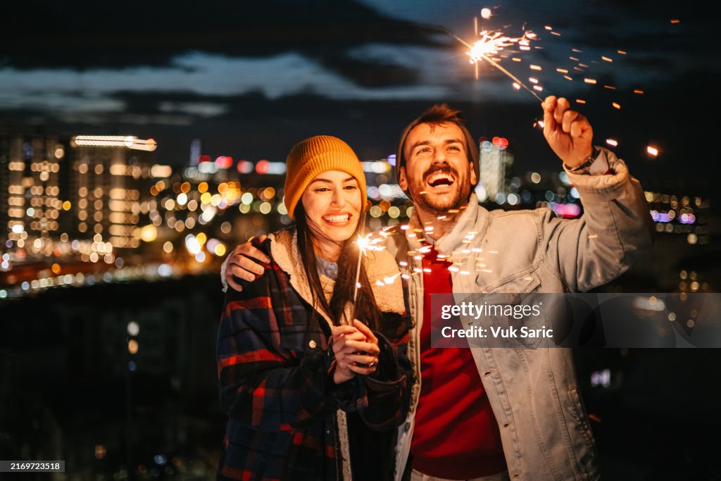 Paar mit Wunderkerzen an einem Silvesterabend