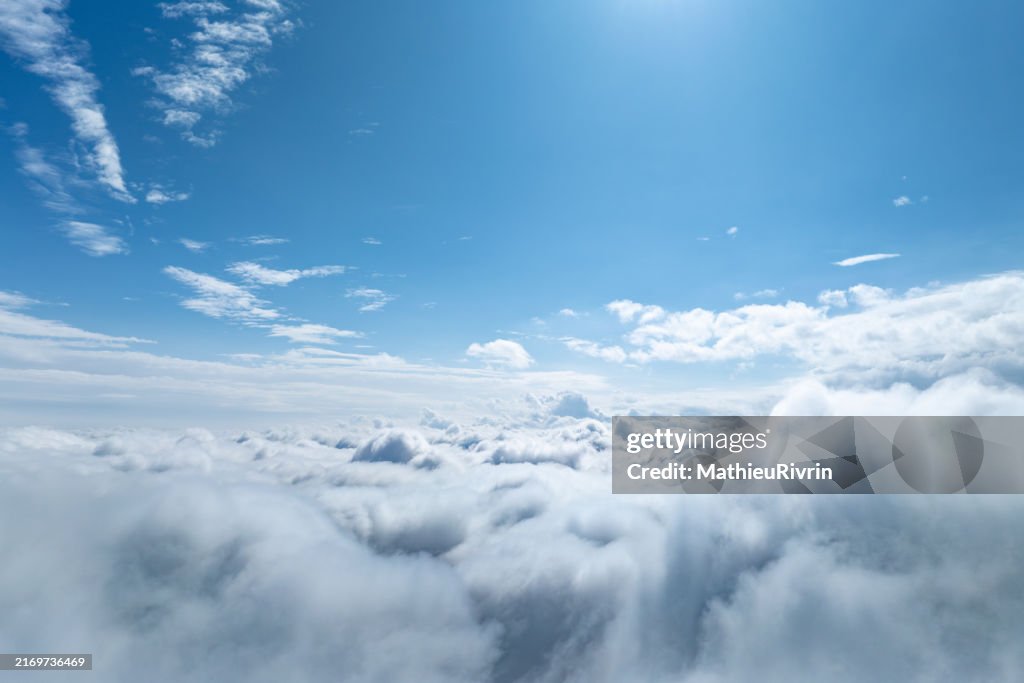 Aerial View of Blue Sky and Clouds Through an Airplane Window