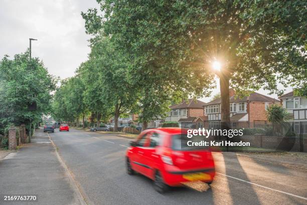 a sunset view of a suburban road in surrey - london car stock pictures, royalty-free photos & images