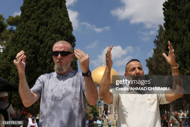 Two men perform the Friday noon prayer in front of the Dome of the Rock mosque in Old Jerusalem's al-Aqsa mosque compound on September 6, 2024.