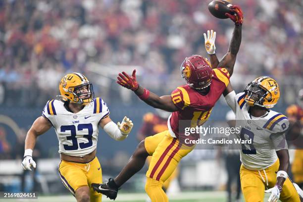 Kyron Hudson of the USC Trojans makes a catch against West Weeks and Major Burns of the LSU Tigers in the second quarter of the Vegas Kickoff Classic...