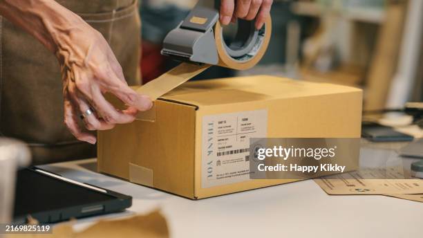 a small business warehouse worker owner packing and labeling eco friendly brown paper honeycomb wrapped with environmental sustainability friendly paper biodegradable materials before shipping to customers,zero waster and plastic free concept - étiqueter photos et images de collection