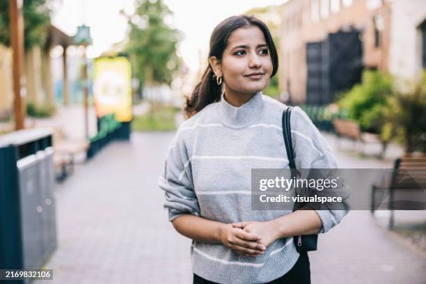 indian businesswoman heads to her office with a positive expression - estonia women stock pictures, royalty-free photos & images