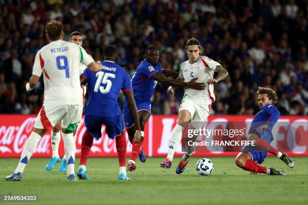 Italy's defender Riccardo Calafiori fights for the ball with France's midfielder Antoine Griezmann and France's midfielder Youssouf Fofana during the...