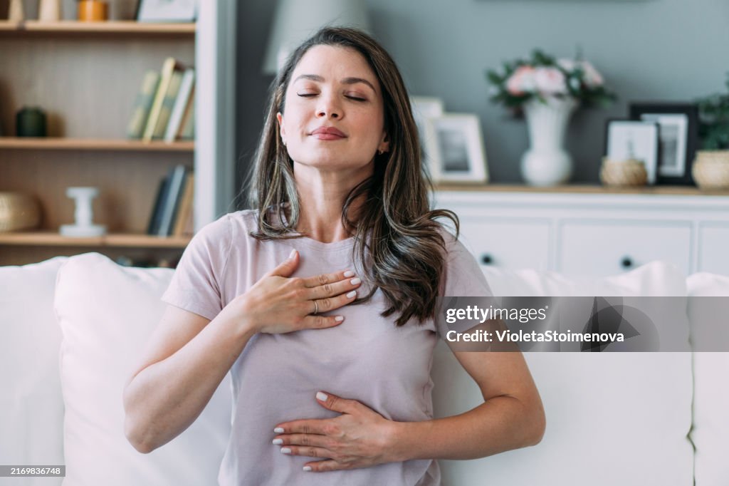 Femme faisant des exercices de respiration apaisante à la maison.