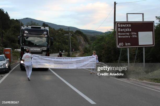 Protesters who began a protest and partial blockade at the Jarinje border crossing between Serbia and Kosovo carry a banner outlining nine demands,...