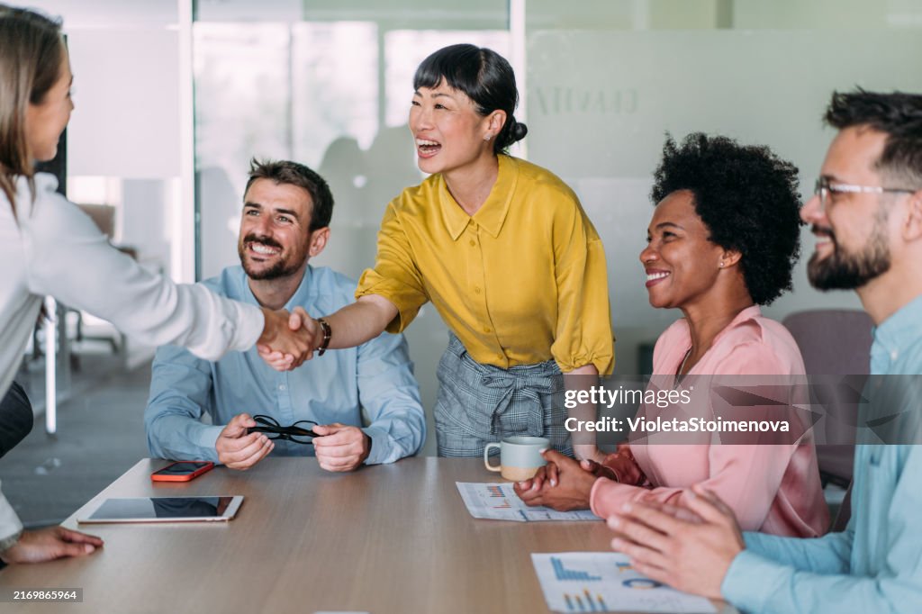 Businesswomen shaking hands across the table.