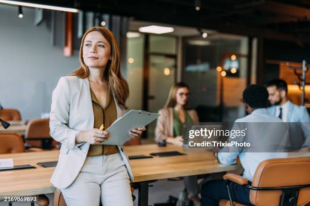 empresaria segura de sí misma y su equipo. - comercio fotografías e imágenes de stock