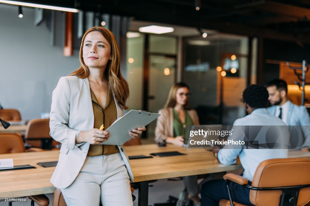 Femme d’affaires confiante et son équipe.