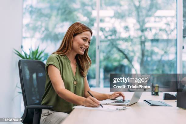 successful businesswoman in modern office working on laptop. - sales executive stock pictures, royalty-free photos & images