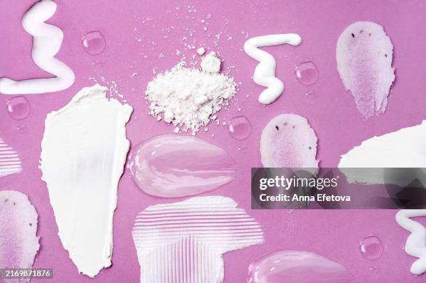 various textures of cosmetic creams, lotions, serums, and exfoliants spread across a purple background. includes creamy moisturizers, translucent gel serums, exfoliating scrubs with particles, and fine cosmetic powders. ideal for highlighting skincare pro - shea butter stock pictures, royalty-free photos & images