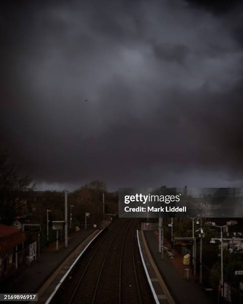 ominous black clouds over train station - station place stock pictures, royalty-free photos & images