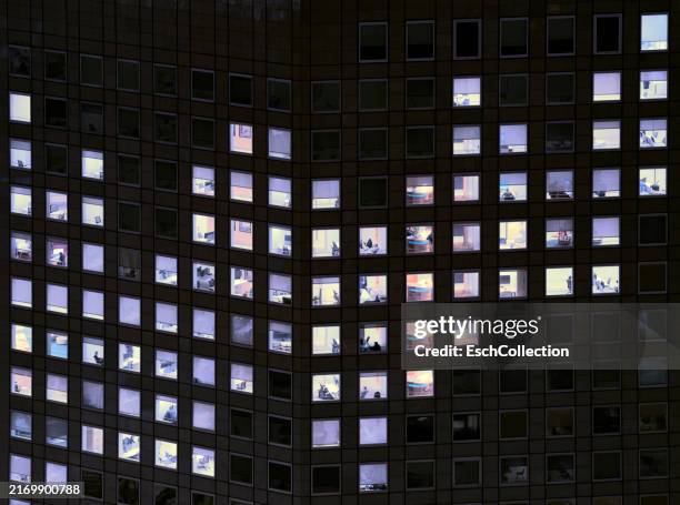 office building with illuminated window pattern, showing rising graph - herhaling begrippen stockfoto's en -beelden