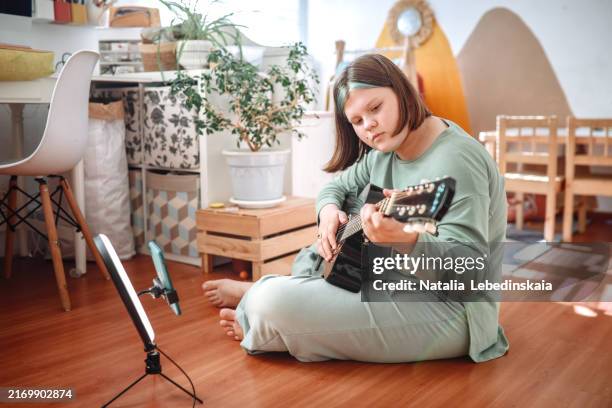 home studio: plus-size teen girl recording guitar lessons online in her room - self recording stock pictures, royalty-free photos & images