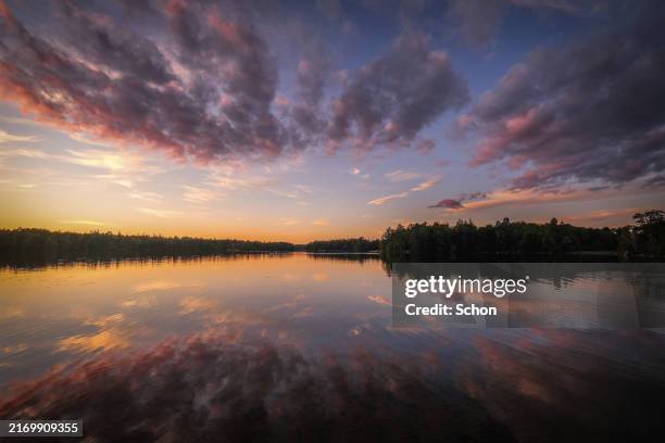 cloudscape by a still lake on a summer evening - september stockfoto's en -beelden
