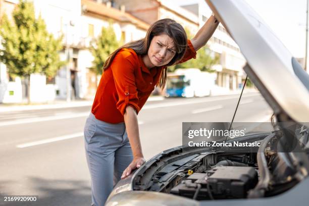 kämpfende frau repariert auto allein während der autofahrt - kaputt stock-fotos und bilder