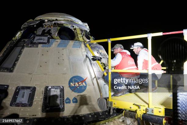 This handout image supplied by NASA shows Boeing and NASA teams work around NASA's Boeing Crew Flight Test Starliner spacecraft after it landed...