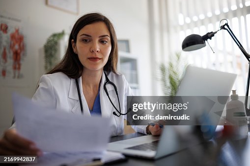 Femme médecin travaillant sur ordinateur portable dans le bureau Femme médecin travaillant sur ordinateur portable dans le bureau