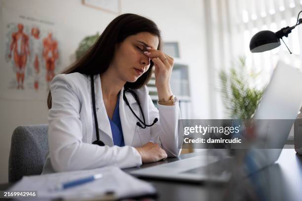 overworked female doctor in her office - tired healthcare worker stock pictures, royalty-free photos & images