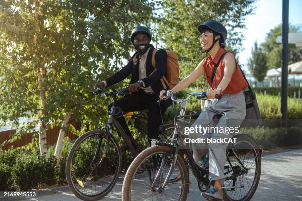 two cyclists riding along a scenic path on a sunny day - ciclista foto e immagini stock