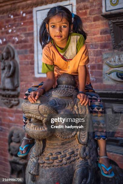 little nepali girl having fun on hindu temple in bhaktapur - nepal children stock pictures, royalty-free photos & images