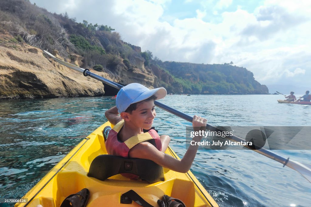 Rear view of a child doing sports in Kayak, Malaga, Nerja, Spain