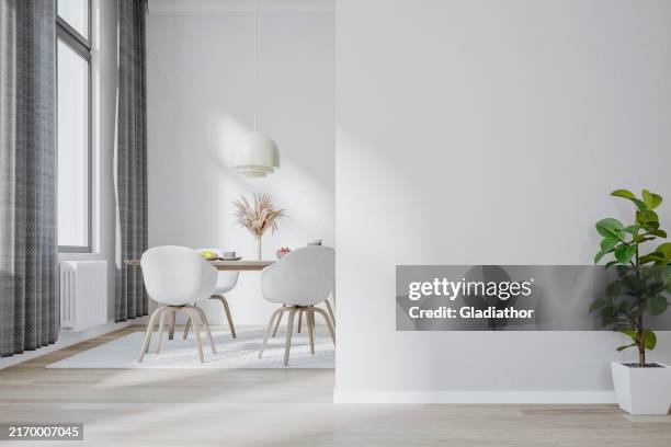 ein luxuriöses, modernes esszimmer (skandinavischer stil) mit einer topfpflanze vor einer weißen, leeren wand und esstisch und stühlen, fenster im hintergrund - speisezimmer stock-fotos und bilder