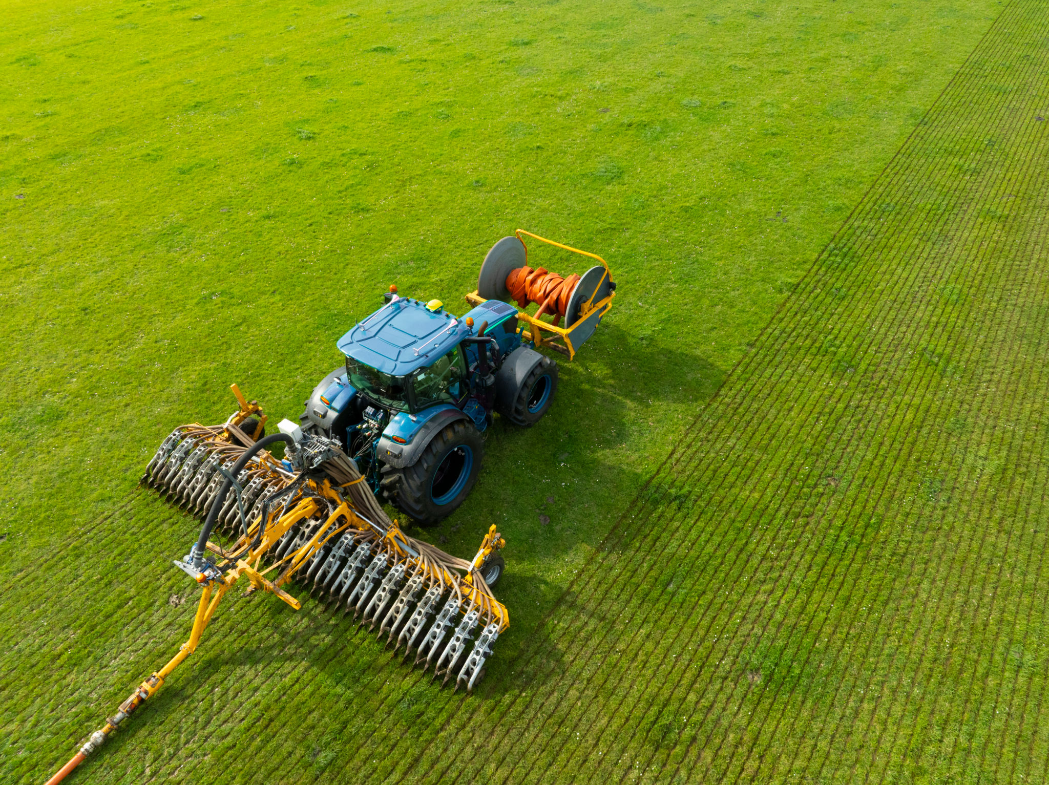 Tractor injecting livestock liquid manure in a field seen from above Tractor injecting livestock liquid manure in a field seen from above