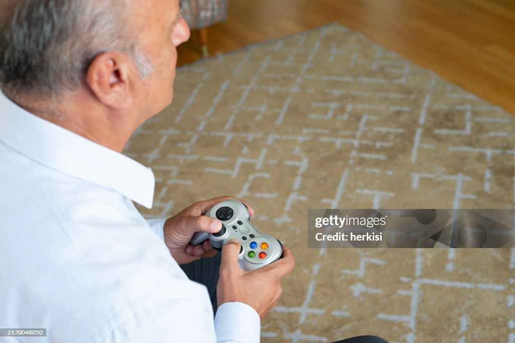 Senior man enjoying video game on playstation, having fun at home