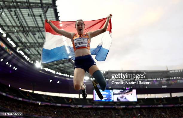 Gold medalist Kimberly Alkemade of Team Netherlands poses for a photo with a Netherlands flag after competing during the Women's 200m T64 Final on...