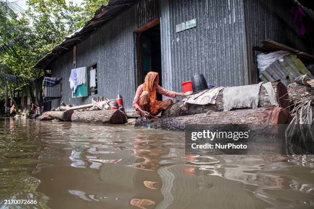 Woman washes necessities in front of her house in the flood water in a village of Chaumuhni Municipality in Noakhali District of Chittagong Division,...