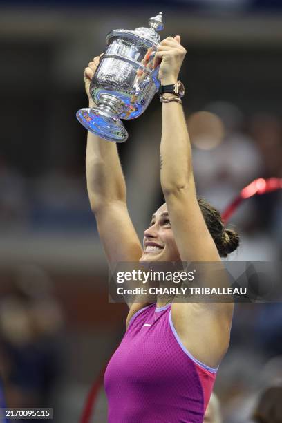 Belarus's Aryna Sabalenka holds up the trophy after defeating USA's Jessica Pegula during their women's final match on day thirteen of the US Open...