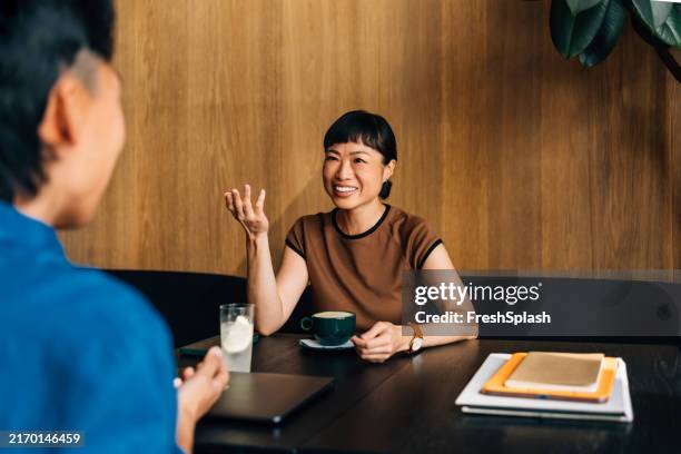 friendly business meeting in a modern coffee shop setting - coffee shop stock pictures, royalty-free photos & images