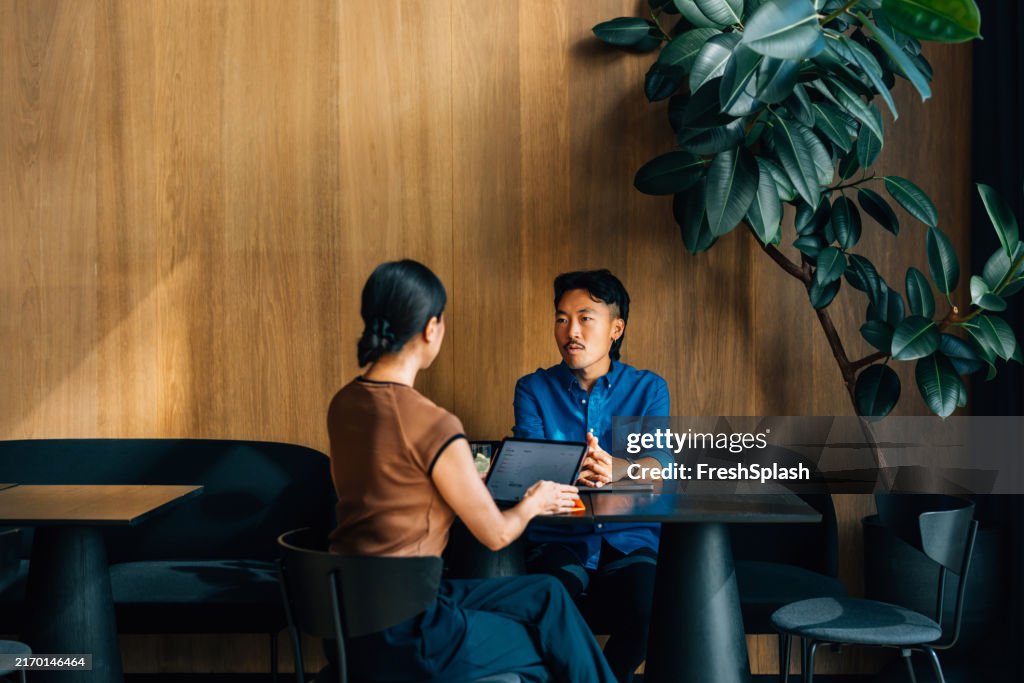 Colleagues Engaged in a Business Meeting at a Modern Cafe