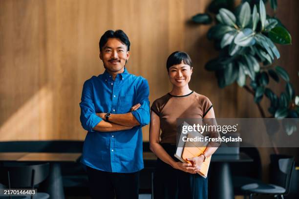 confident professionals posing in modern office setting - young japanese women stock pictures, royalty-free photos & images
