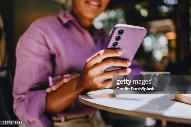 woman relaxing with smartphone in a cozy cafe setting - lilac stock pictures, royalty-free photos & images