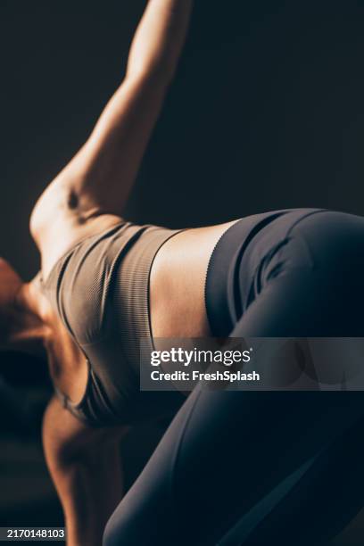 woman practicing yoga stretching in athletic wear - yoga imagens e fotografias de stock