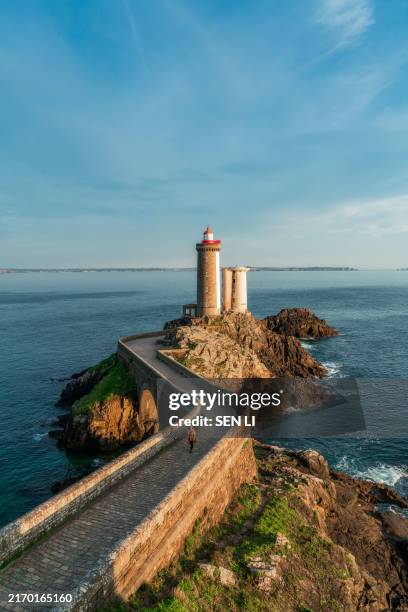 petit minou lighthouse and its headland, aerial view at sunset with a woman walking through the bridge - brest brittany stock pictures, royalty-free photos & images
