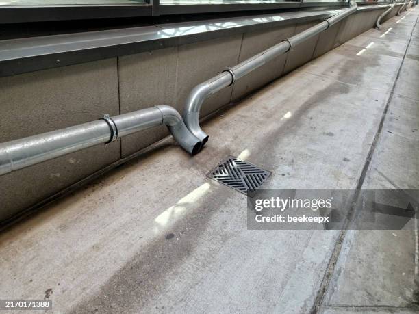 two pipes of the gutter of the roof lead to the grid channel where the water flows out