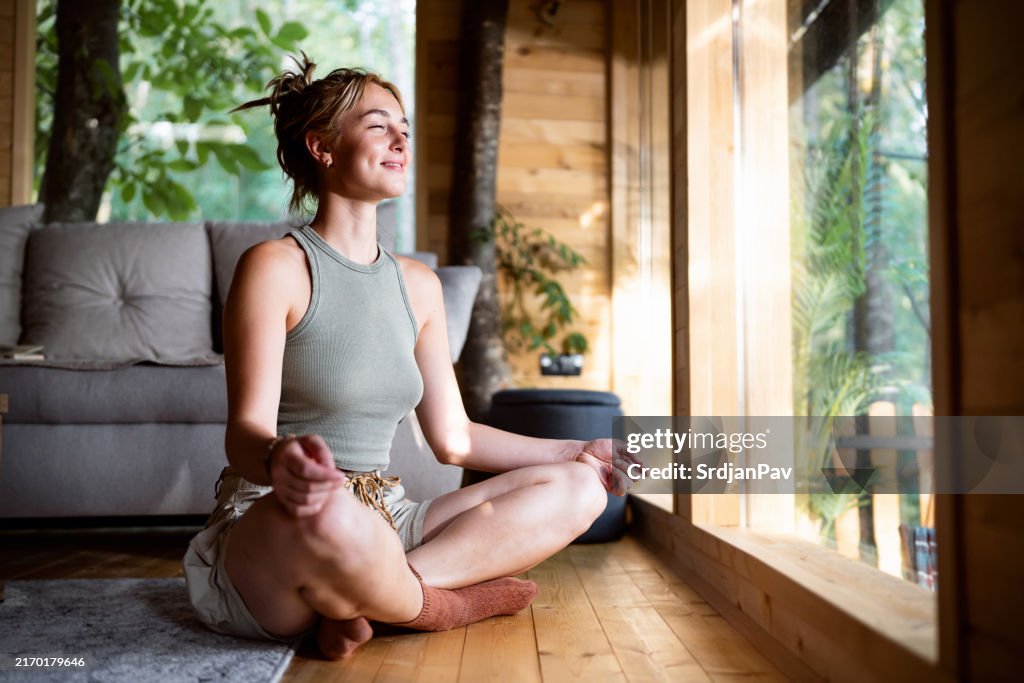 Young Caucasian woman mediating, from the tree house