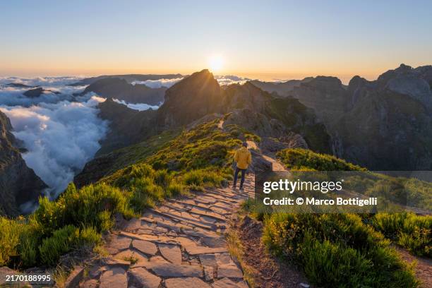 man admiring sunset from pathway on mountain ridge - pico do arieiro fotografías e imágenes de stock