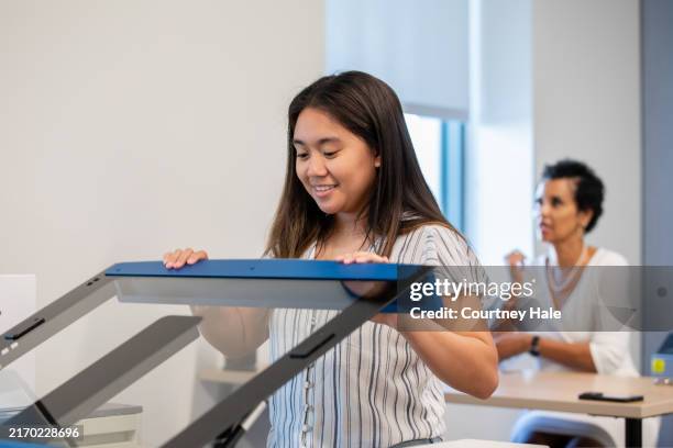 teenage student uses laser engraver in makerspace stem lab - laser engraving stock pictures, royalty-free photos & images