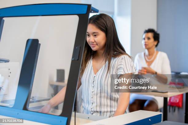 teenage college student uses laser engraver in makerspace stem lab classroom - laser engraving stock pictures, royalty-free photos & images