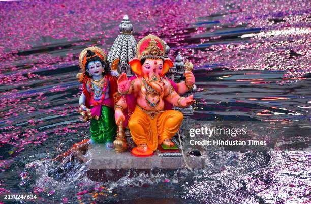 Volunteer immerses Lord Ganesha idol in an artificial pond during the one-and-half day Ganpati immersion, at Dadar, on September 8, 2024 in Mumbai,...